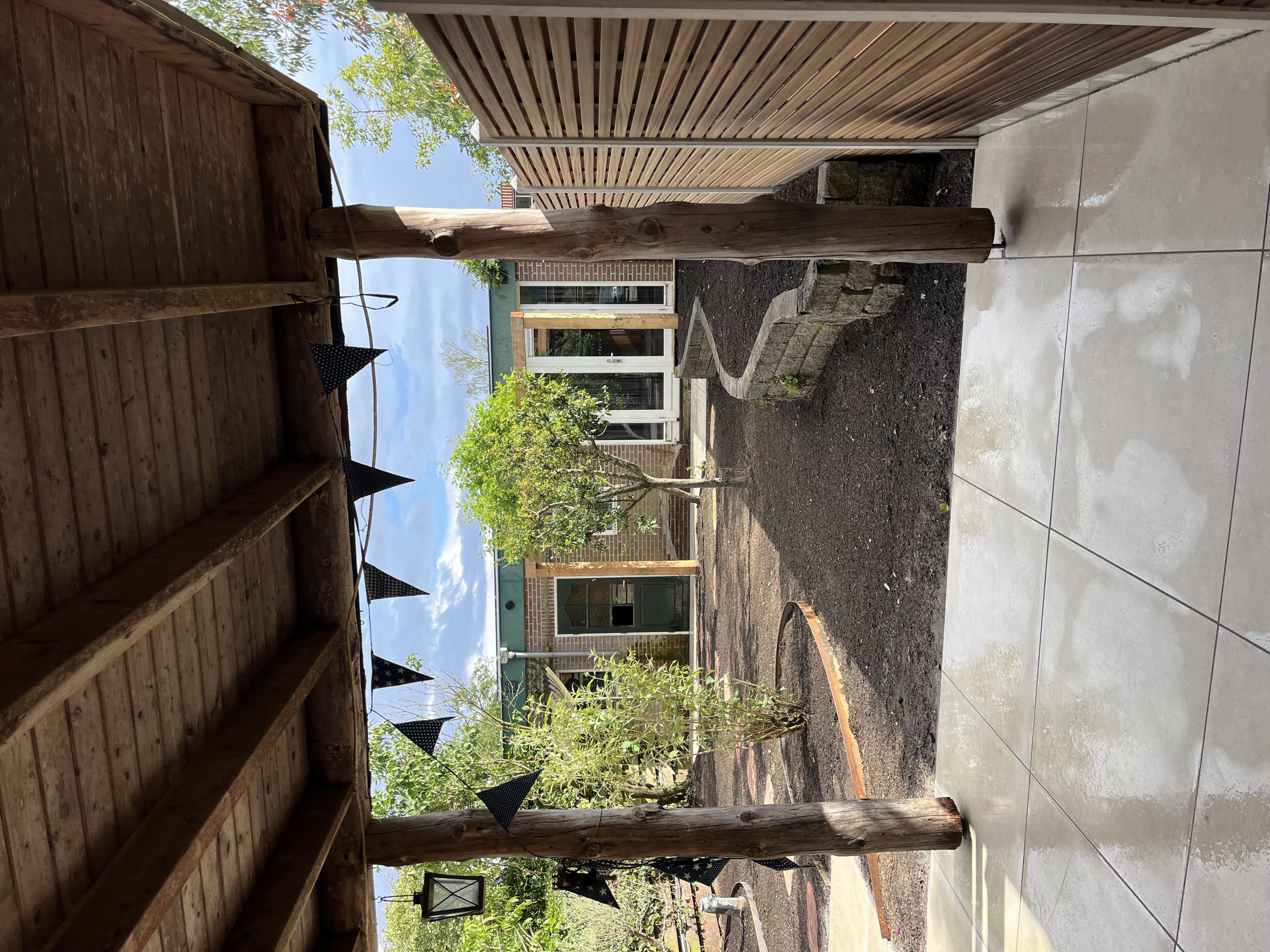 Pergola in aanbouw met keramische bestrating eronder